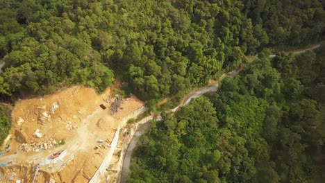 Aerial-view-Construction-work-beside-the-green-forest-at-Asia-country
